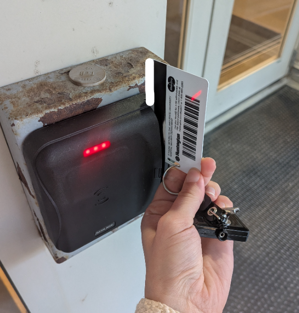 BuckID being swiped at a Lenel card reader at Prior Hall, with the magnetic stripe facing left on the new tap-enabled reader.