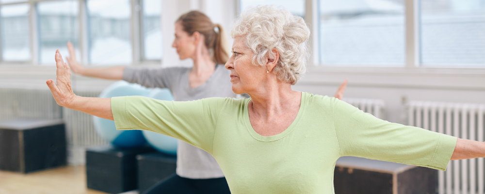 Two women in a warrior yoga pose