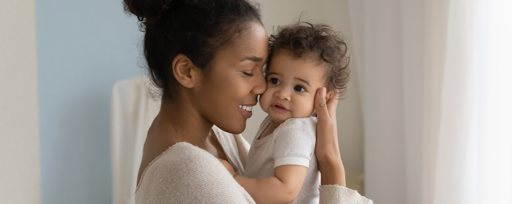 woman holding her baby and smiling