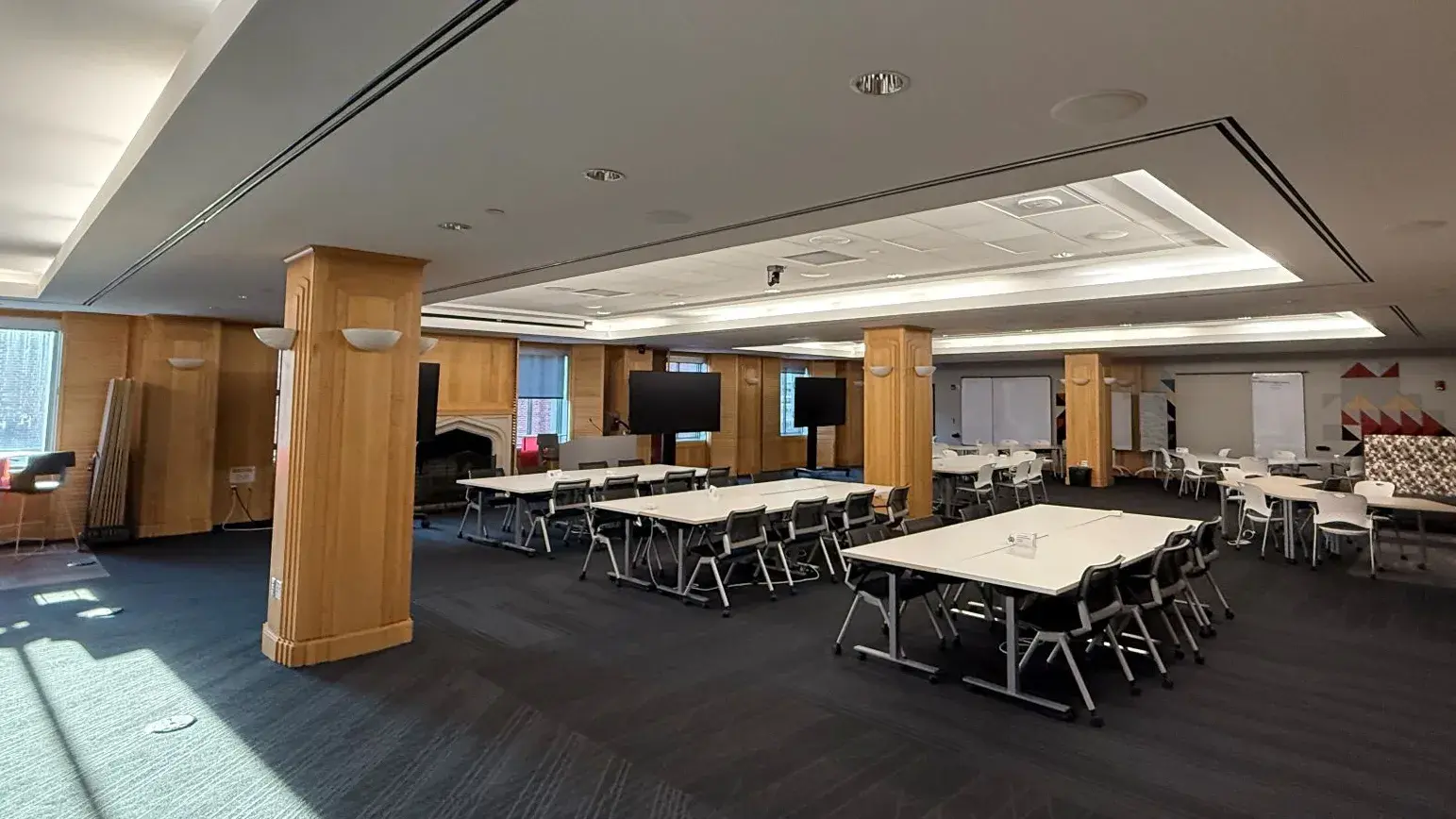 Interior of Health Science Library's 550 Conference room featuring a large carpeted room with several tables and chairs.