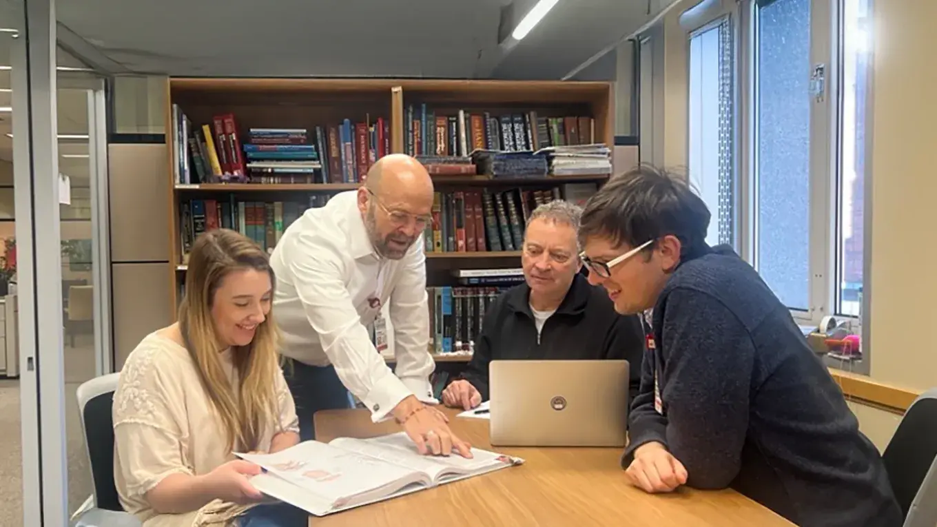 professors and students in a meeting room within Prior Hall 