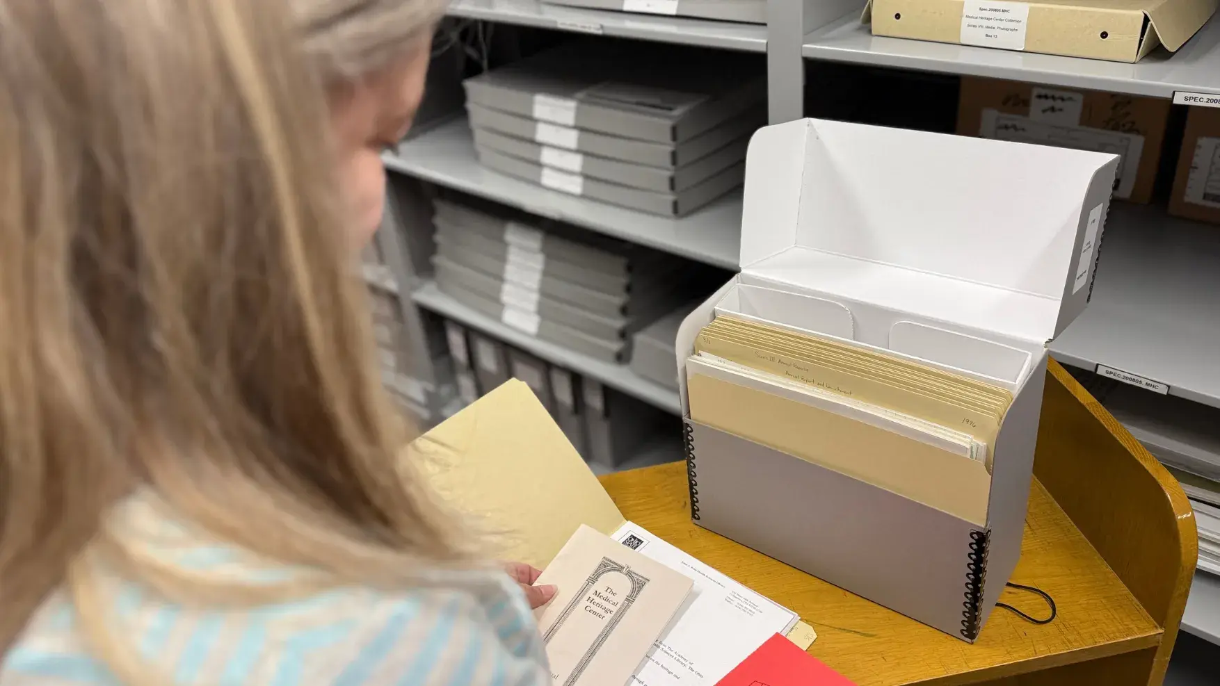 A woman looks at records in an archives environment