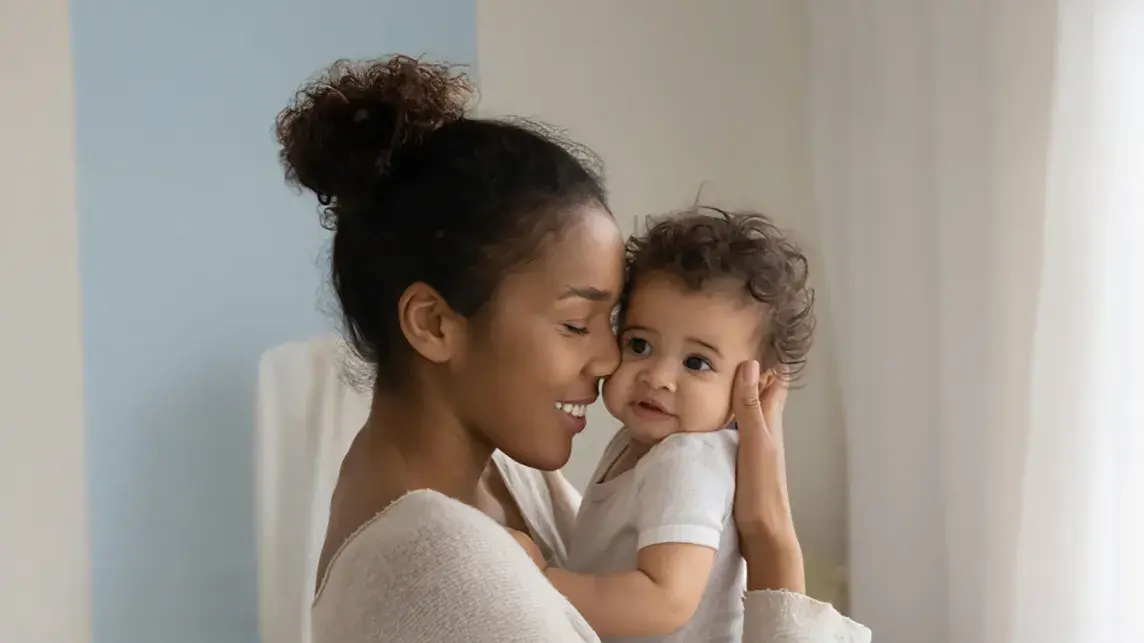 mother snuggling her child in her arms 