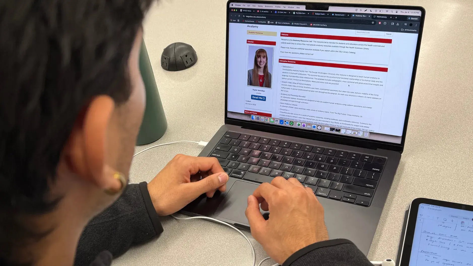A student looking at a subject guide on a laptop