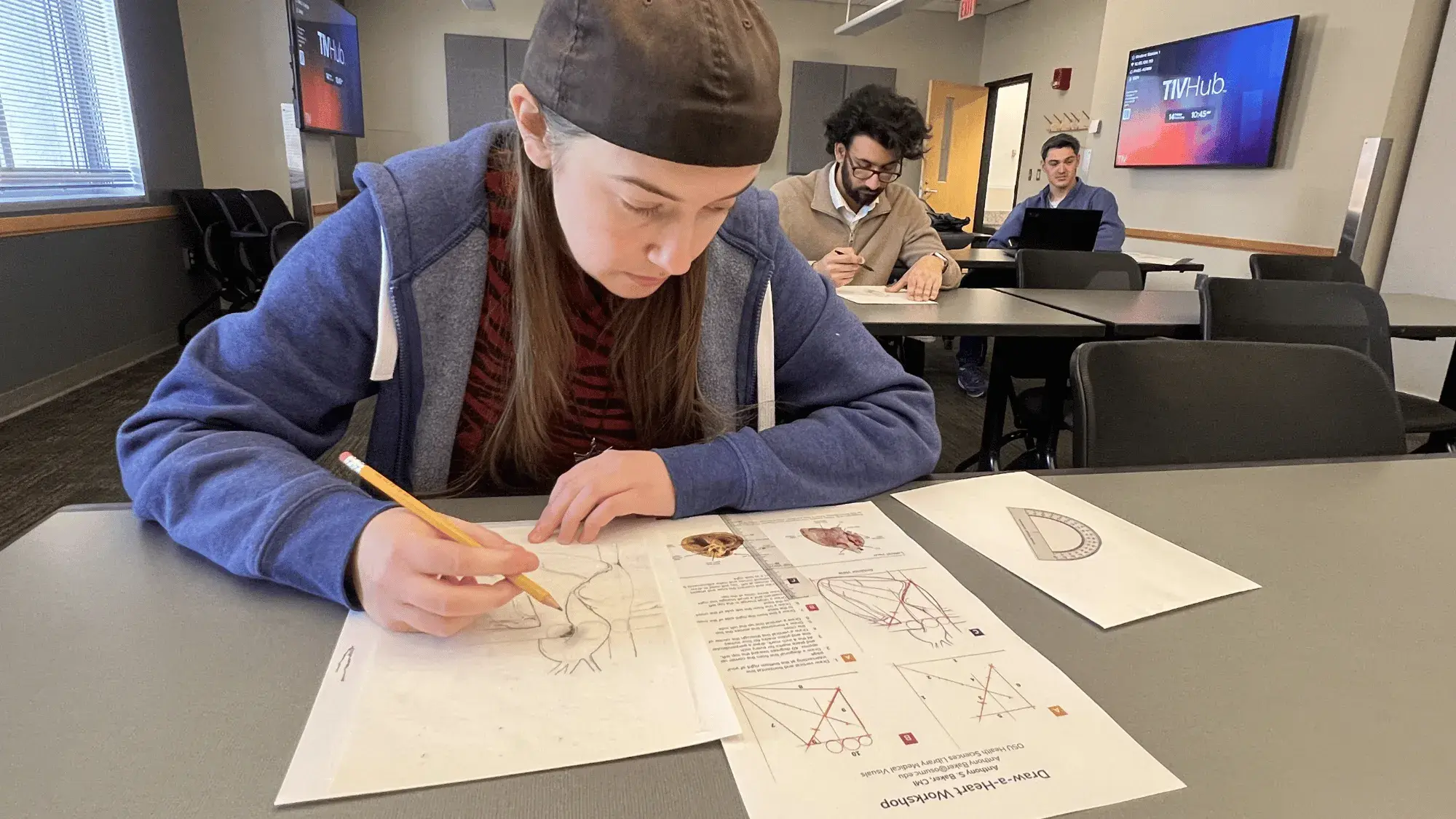 A student works on her drawing in an anatomy drawing class