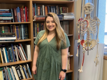 Courtney Fleming standing in front of bookcase and skeleton model