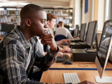 man in plaid shirt looking at a laptop