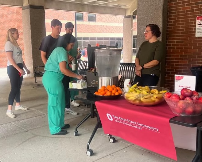 people enjoying fruits at the HSL event in front of Prior Hall
