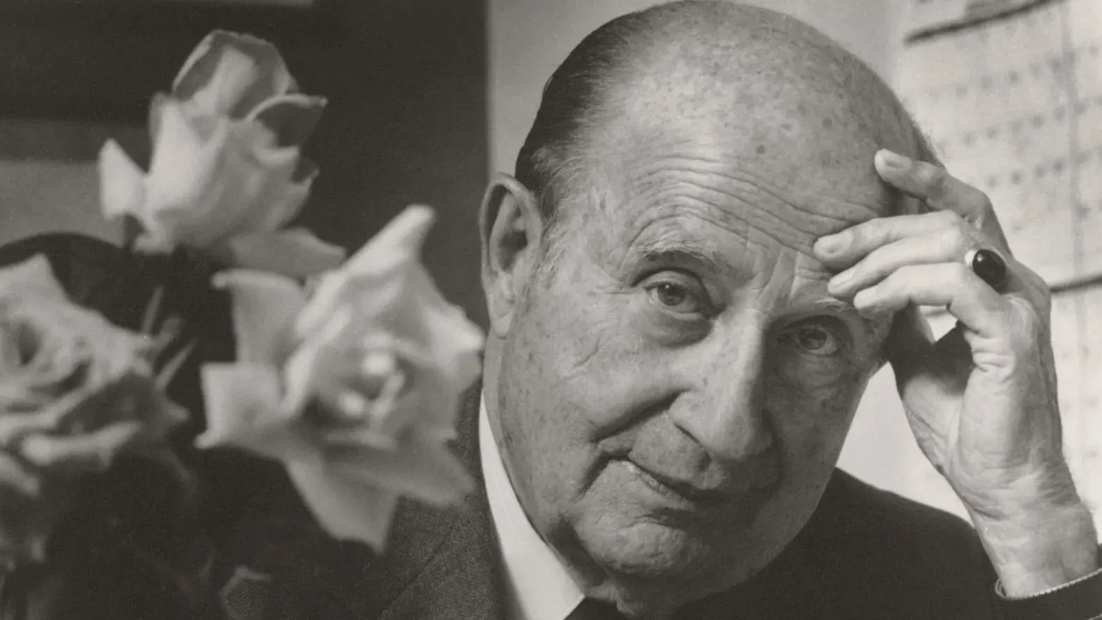 black and white robert zollinger portrait next to freshly cut roses