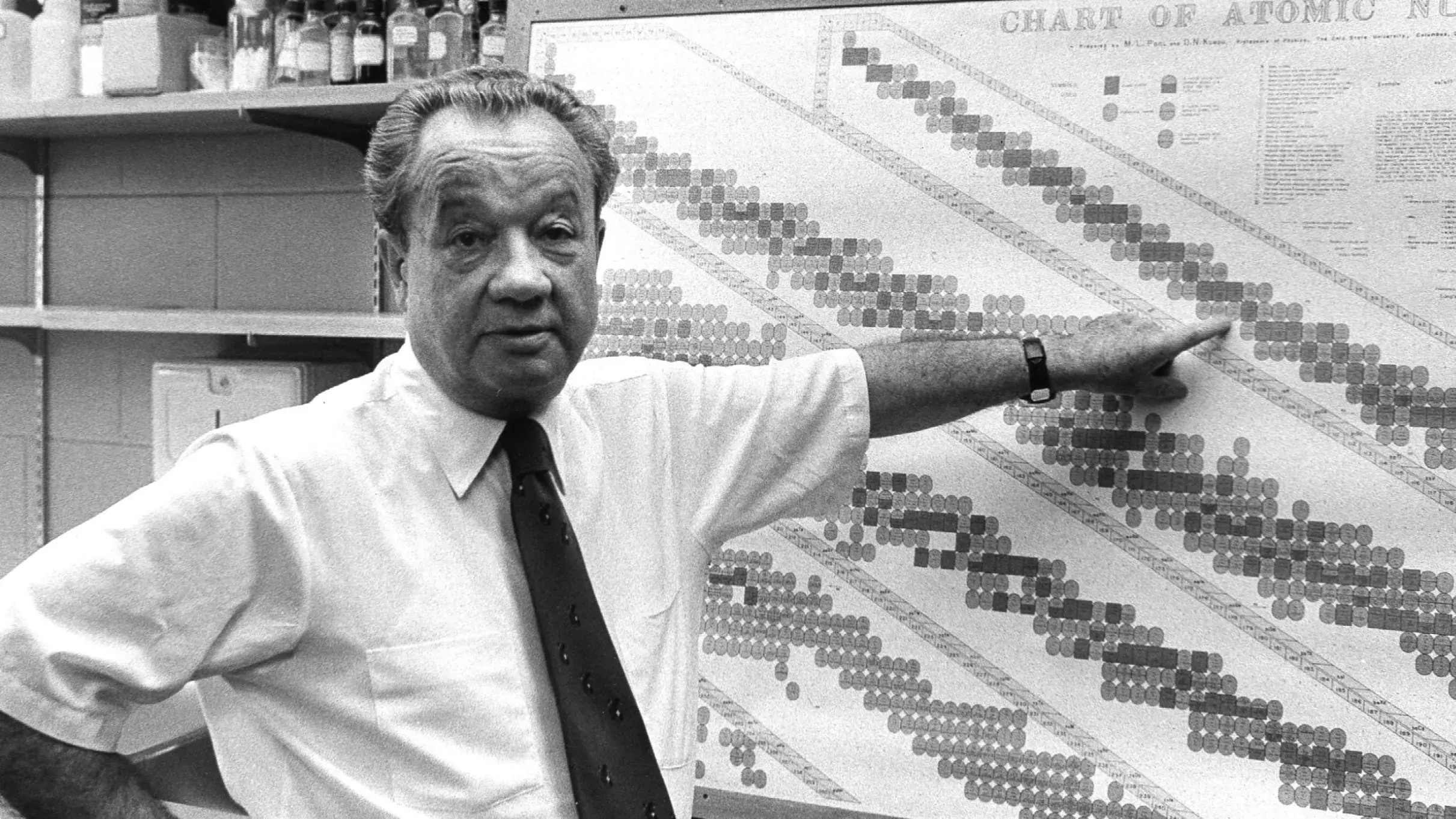 william g. myers points to a chart of atomic numbers
